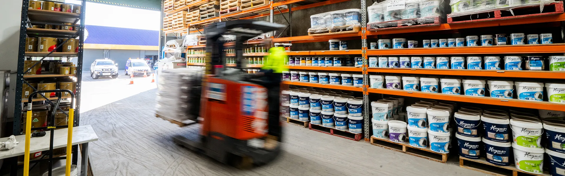 Forklift operator driving through Network Render & Paint warehouse